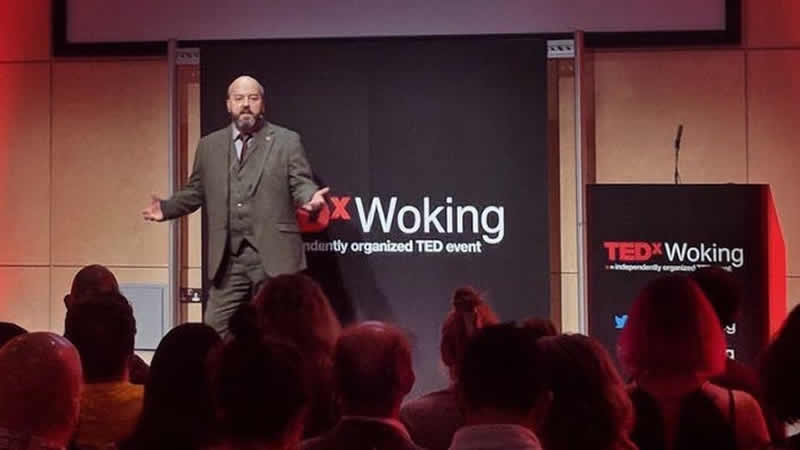 A man stood on a stage giving a talk